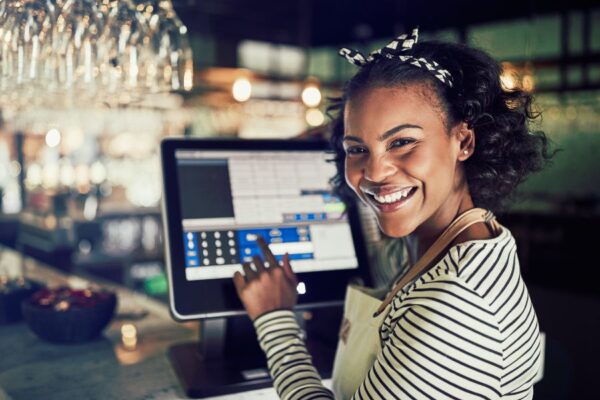 restaurant staff smiling while using a point of sale system