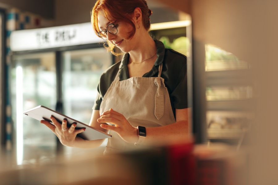 grocery store working holding a mobile POS